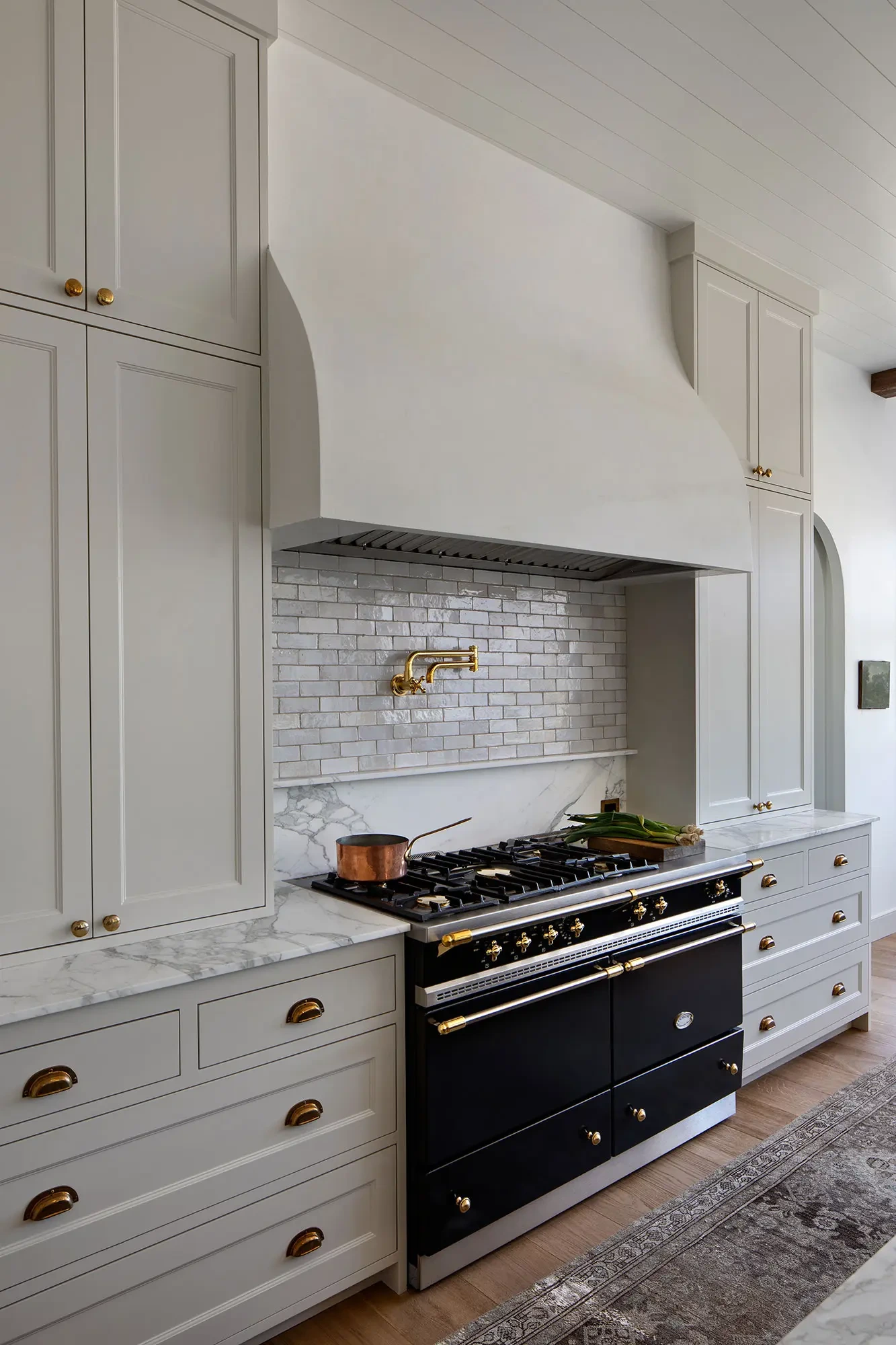 La Mesa by GHG Builders — range and custom hood with brick backsplash