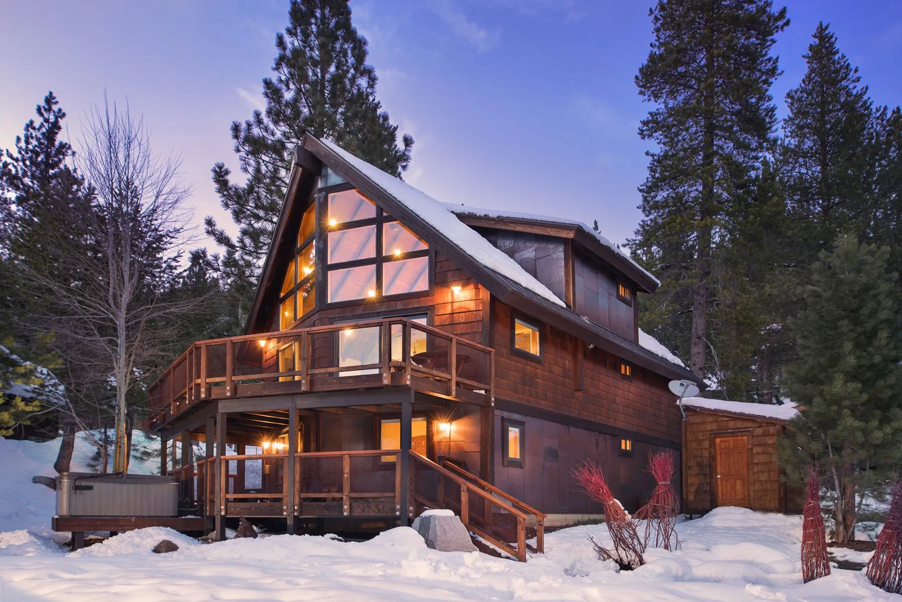 Tiger Tail by GHG Builders — mountain home lit at dusk in the snow